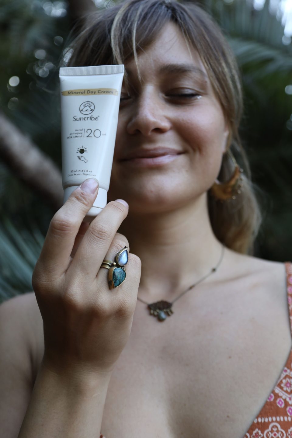 protezione solare minerale tenuta in mano da una ragazza sorridente